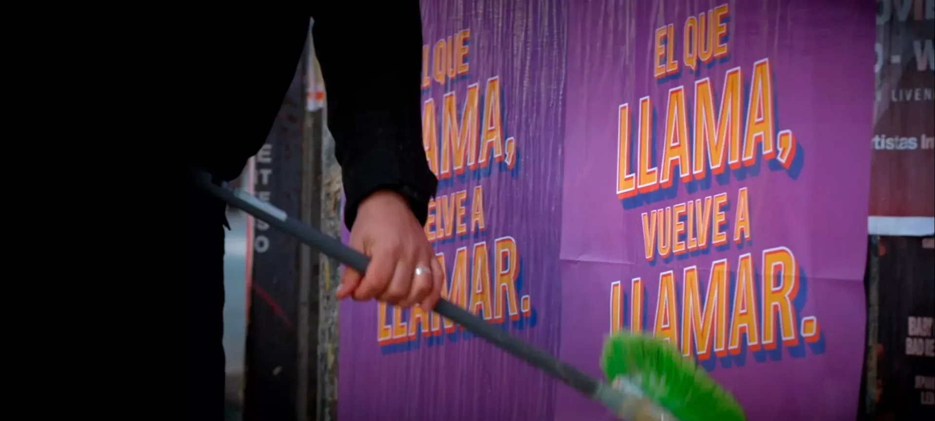 Un chico pegando un cartel en una pared